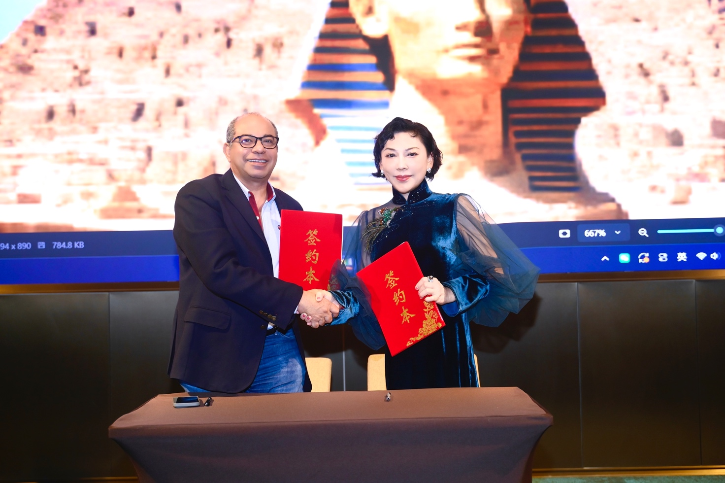 A person and person shaking hands
Description automatically generated